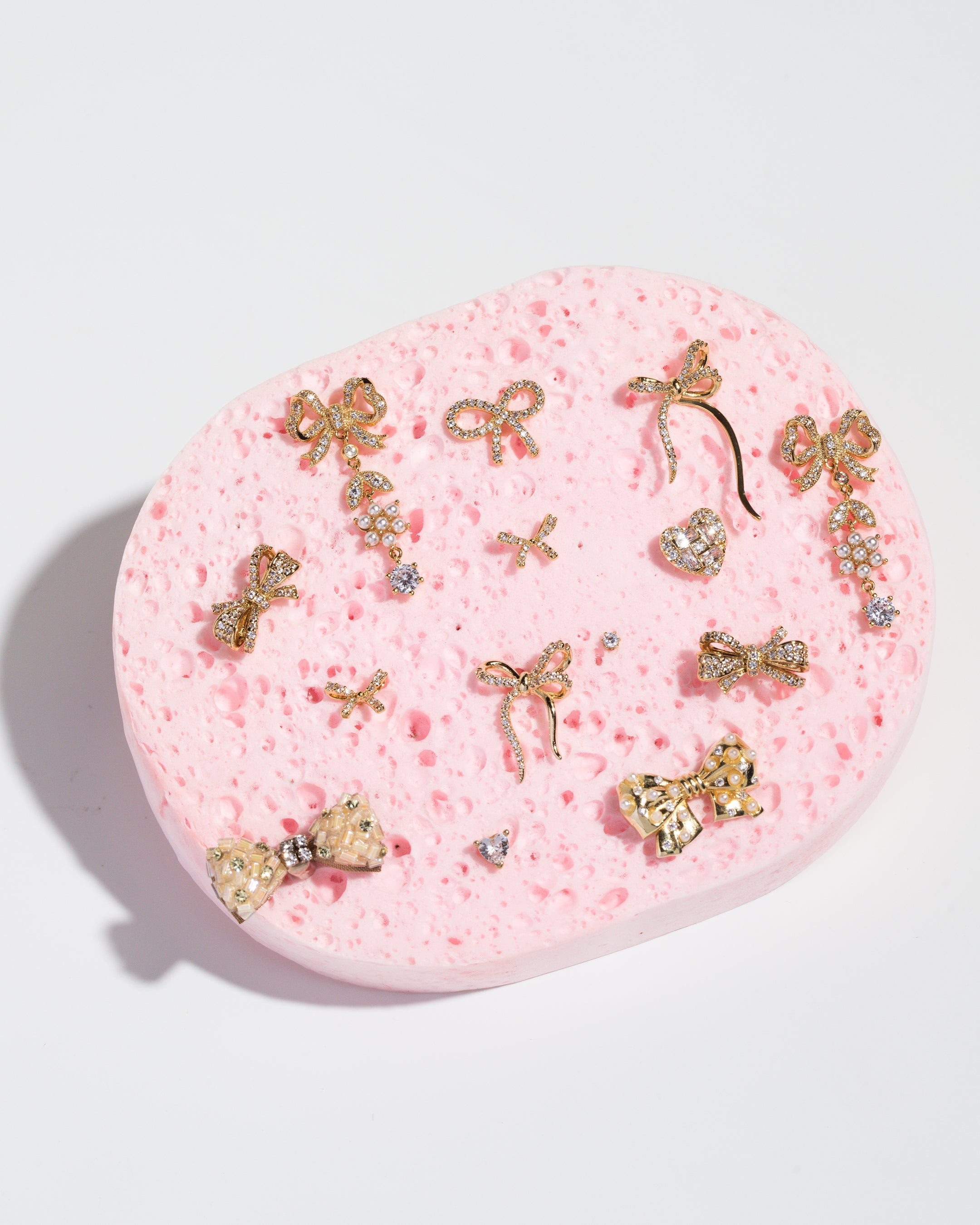 Bow studs displayed on a pink sponge